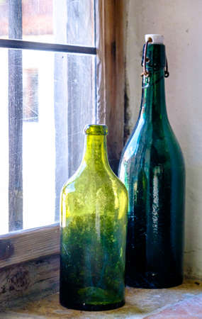 old bottles at a windowの写真素材