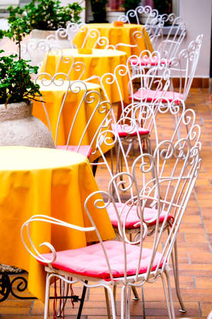 table and chairs at a sidewalk cafeの写真素材