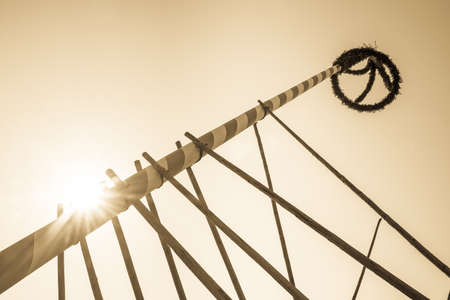 typical bavarian maypole in front of blue skyの写真素材