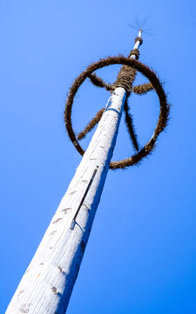 typical old maypole in front of blue skyの写真素材