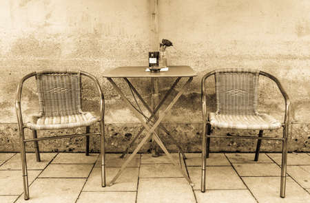 table and chairs at a sidewalk cafeの写真素材