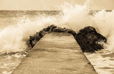 waves splashing at an old pierの写真素材