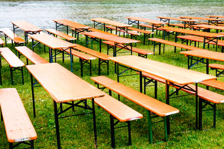 bavarian beergarden - table and benches at a riverの写真素材