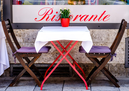 table and chairs at a sidewalk restaurantのeditorial素材