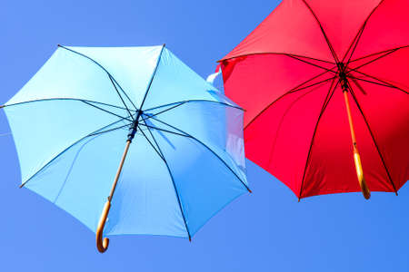 flying umbrellas in front of blue skyの写真素材