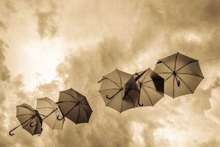 flying umbrellas in front of blue skyの写真素材