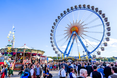 MUNICH, GERMANY - SEPTEMBER 21: people and fairground rides at the biggest folk festival in the world - the octoberfest on september 21, 2017 in munich. Since 1810 it takes place on the Theresienwiese in the Bavarian state capital Munich.のeditorial素材