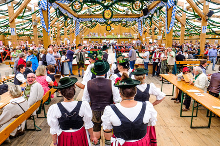 MUNICH, GERMANY - SEPTEMBER 21: people in the "traditon"-beer tent at the biggest folk festival in the world - the octoberfest on september 21, 2017 in munich. Since 1810 it takes place on the Theresienwiese in the Bavarian state capital Munich.のeditorial素材