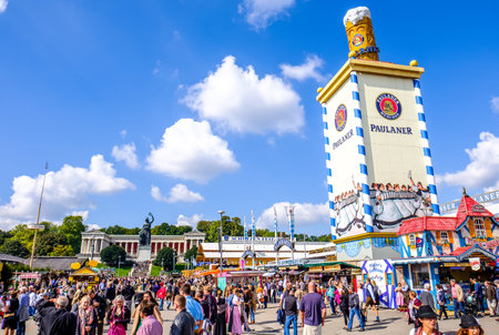 MUNICH, GERMANY - SEPTEMBER 21: people and fairground rides at the biggest folk festival in the world - the octoberfest on september 21, 2017 in munich. Since 1810 it takes place on the Theresienwiese in the Bavarian state capital Munich.のeditorial素材