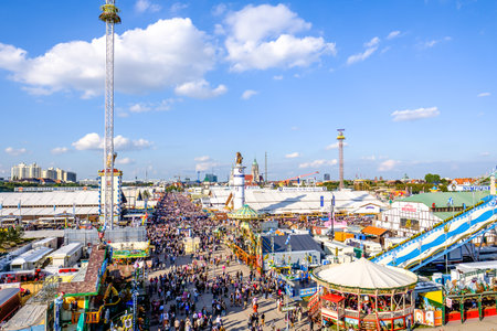MUNICH, GERMANY - SEPTEMBER 21: people and fairground rides at the biggest folk festival in the world - the octoberfest on september 21, 2017 in munich. Since 1810 it takes place on the Theresienwiese in the Bavarian state capital Munich.のeditorial素材