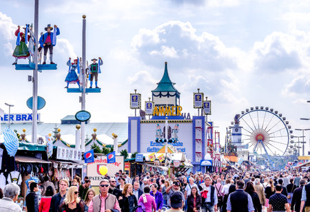 MUNICH, GERMANY - SEPTEMBER 25: people and fairground rides at the biggest folk festival in the world - the octoberfest on september 25, 2017 in munich.のeditorial素材