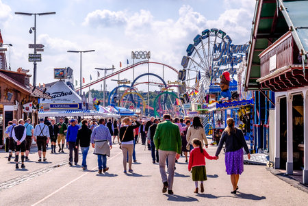 MUNICH, GERMANY - SEPTEMBER 25: people and fairground rides at the biggest folk festival in the world - the octoberfest on september 25, 2017 in munich.のeditorial素材