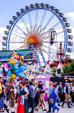 MUNICH, GERMANY - SEPTEMBER 21: people and fairground rides at the biggest folk festival in the world - the octoberfest on september 21, 2017 in munich.のeditorial素材