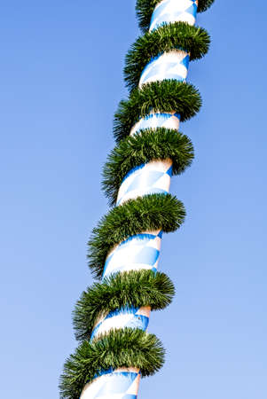 typical bavarian maypole in front of blue skyの写真素材