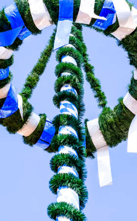 typical bavarian maypole in front of blue skyの写真素材