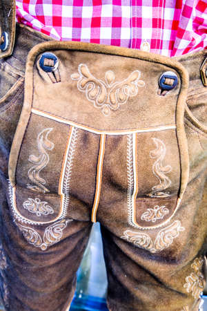 close-up of a typical bavarian "krachlederne" - traditional clothing with antique coinsの写真素材