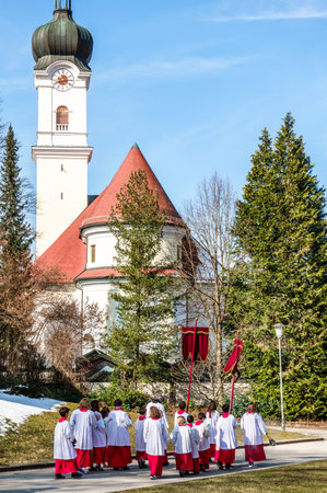 MURNAU, GERMANY - MARCH 25: people at the palm sunday procession in front of the st. nikolaus church in the old town on march 25, 2018 in murnau, Germanyのeditorial素材