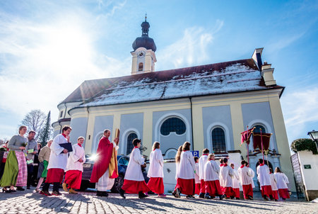 MURNAU, GERMANY - MARCH 25: people at the palm sunday procession in front of the st. nikolaus church...