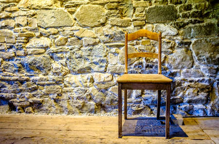 old chair in front of wallの写真素材