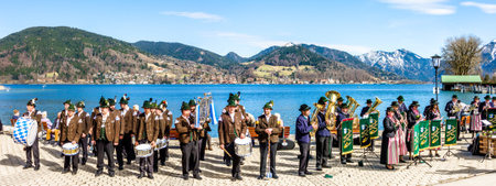 BAD WIESSEE, GERMANY, APRIL 2: typichal local bavarian brass and marching band in front of the tegernsee lake in bad wiessee on april 2, 2018のeditorial素材