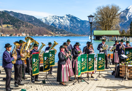 BAD WIESSEE, GERMANY, APRIL 2: typichal local bavarian brass and marching band in front of the tegernsee lake in bad wiessee on april 2, 2018のeditorial素材