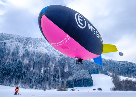 ROTTACH, GERMANY - FEBRUARY 21: blimp (hot air airship) flying at the european alps on feb 21, 2018 in rottach, germanyのeditorial素材