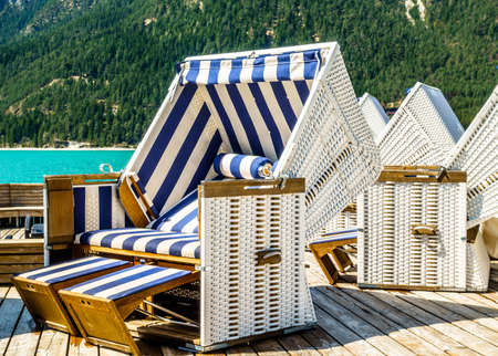 hooded beach chairs at a lakeの写真素材