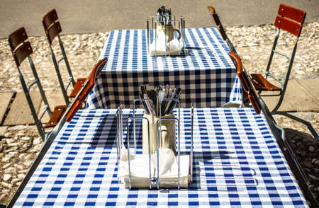 table and chairs at a sidewalk restaurantの写真素材