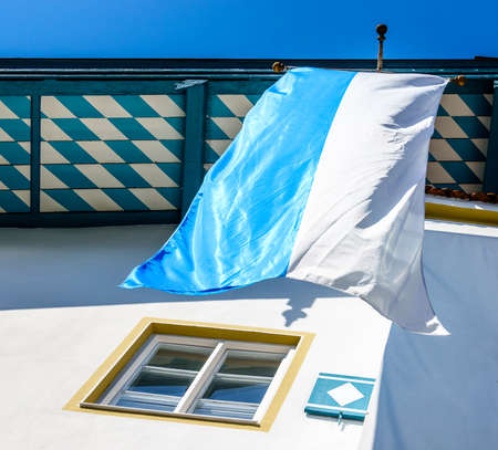 typical bavarian flag in the famous village bad toelz - old townの写真素材