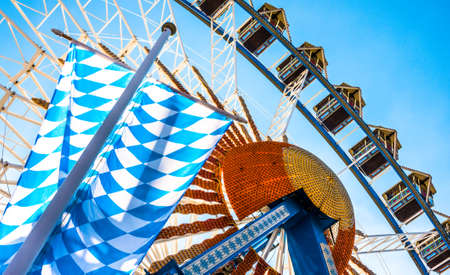bavarian flag in front of ferris wheelの写真素材