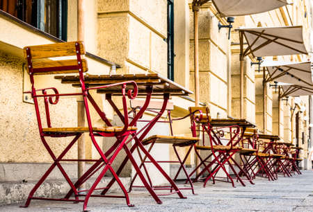 table and chairs at a sidewalk restaurantの写真素材