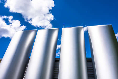 modern industry chimneys in front of blue skyの写真素材