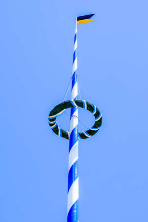 typical bavarian maypole in front of blue skyの写真素材