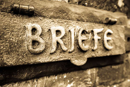 old mail slot at a  wall in germany - translation: letterの写真素材