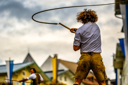 Bad Toelz, Germany - November 6: coachman with traditional clothes and popping whip at the annual leonhardifahrt procession on November 6, 2019 in bad toelz, germanyのeditorial素材