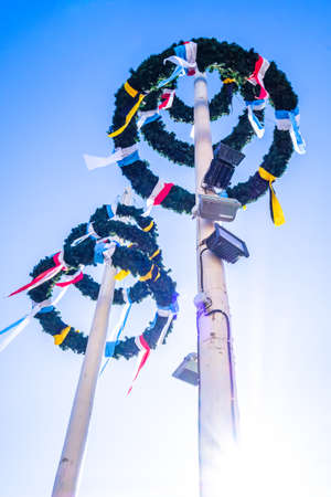 typical bavarian maypole in front of blue skyの写真素材