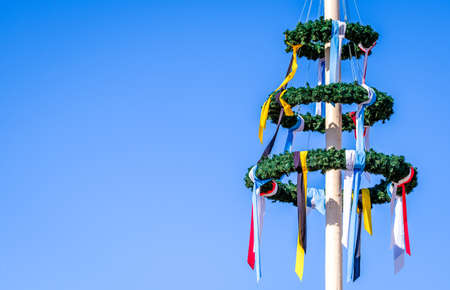 typical bavarian maypole in front of blue skyの写真素材
