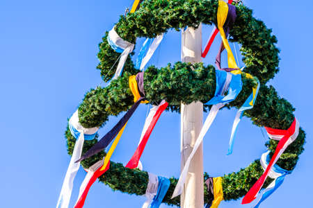 typical bavarian maypole in front of blue skyの写真素材