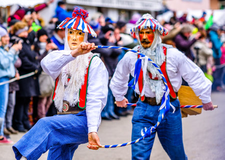 Mittenwald, Germany - February 20: participants of a parade with traditional disguise with large wooden masks and historic costumes called 'maschkera' on February 20, 2020 in Mittenwaldのeditorial素材
