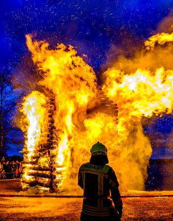 Seeshaupt, Germany - March 27: Firefighter guarding a traditional Bavarian Easter fire in Seeshaupt on March 27, 2016のeditorial素材