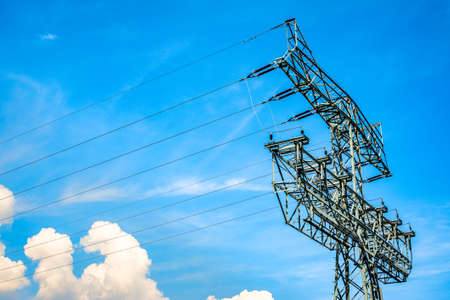 modern electricity pylon in front of blue skyの写真素材