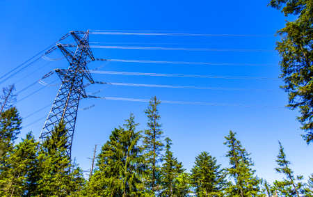 modern electricity pylon in front of blue sky