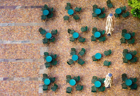 table and chairs at a sidewalk restaurant in italy