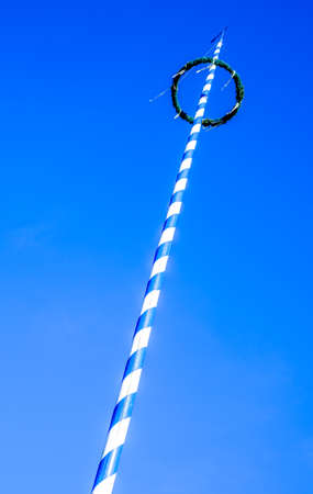 typical maypole in bavaria with the bavarian coat of arms - germanyの写真素材