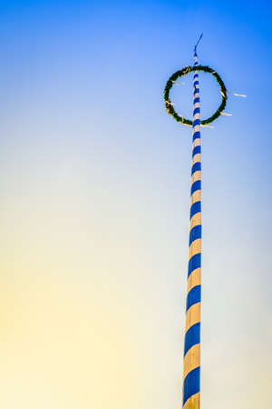 typical maypole in bavaria with the bavarian coat of arms - germanyの写真素材