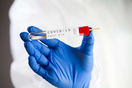 COVID-19 virus disease self swab test sample kit, medical laboratory scientist holding a test tube...