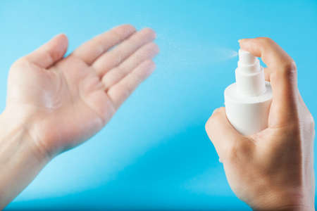 Female caucasian hands spraying antibacterial alcohol sanitizer,protection from spread and transfer...