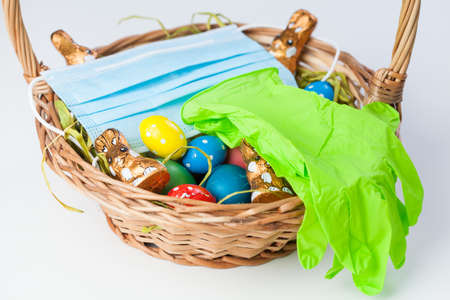 Easter basket with medical face mask and latex rubber gloves,traditional festive holiday in time of...