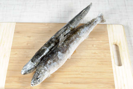 The frozen fish on a chopping board.