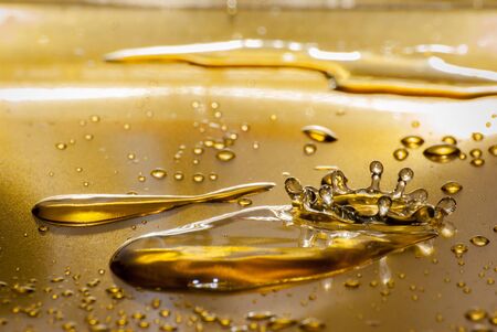 Water drops in detail on gold plateの写真素材